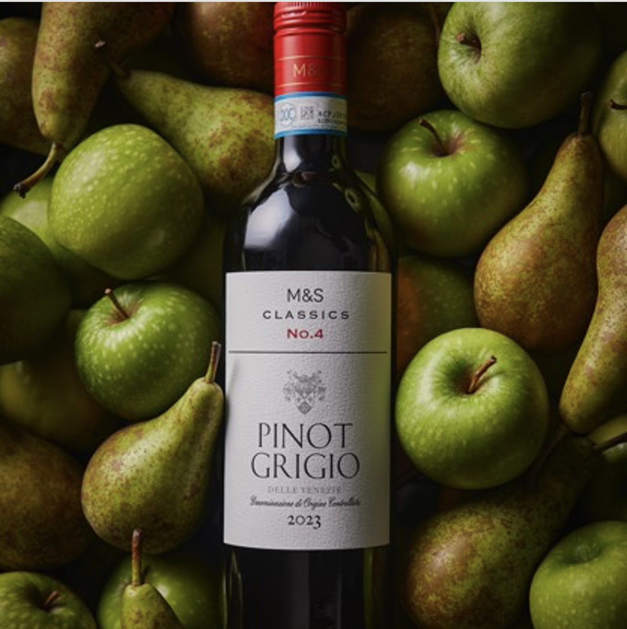 a bottle of wine on a pile of pears