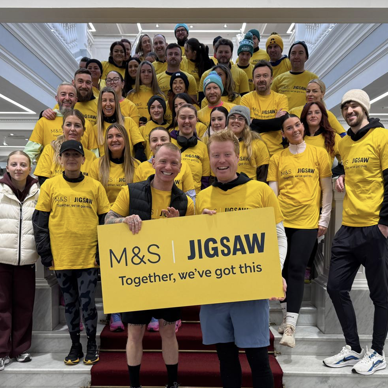 a group of people wearing yellow t-shirts with the word 'Jigsaw' on them