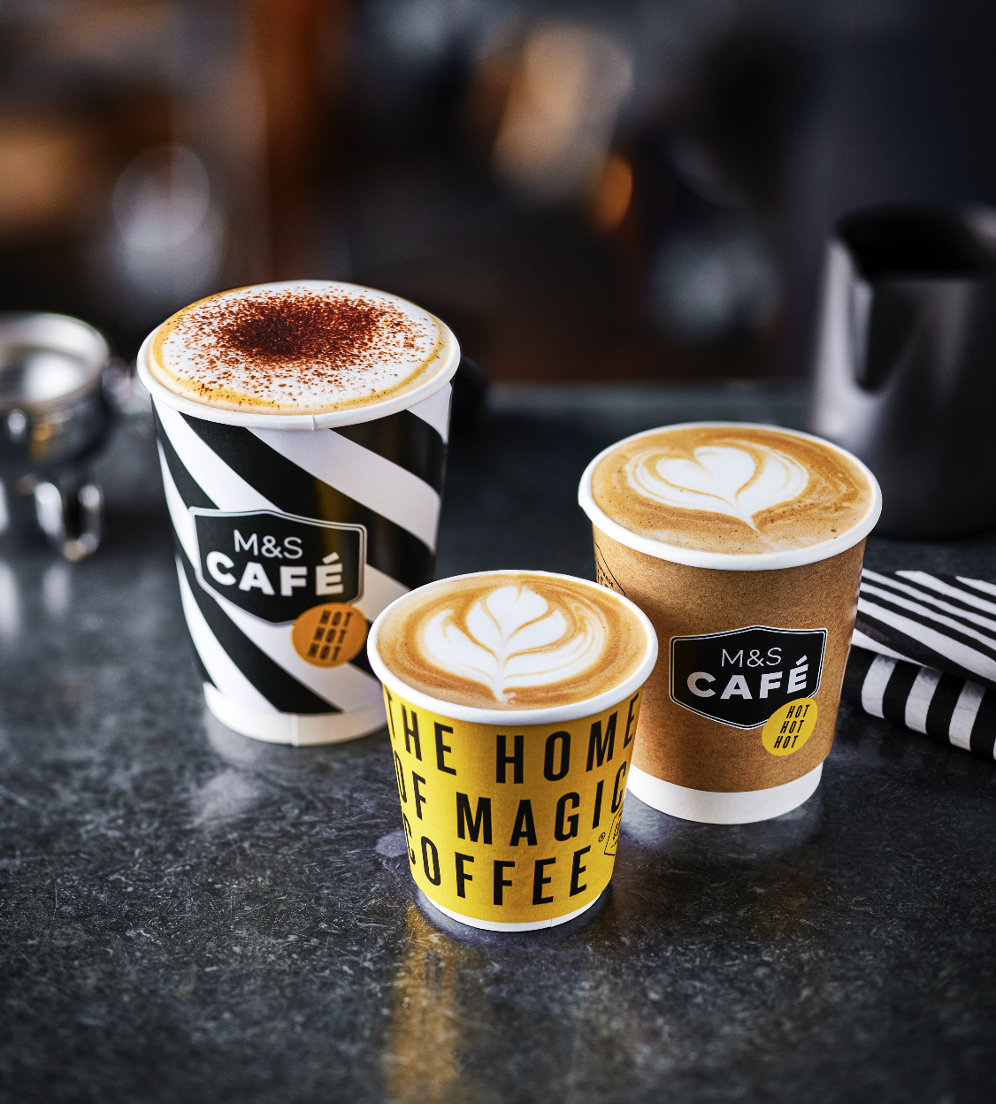 Three paper fibre recyclable coffee cups filled with coffee