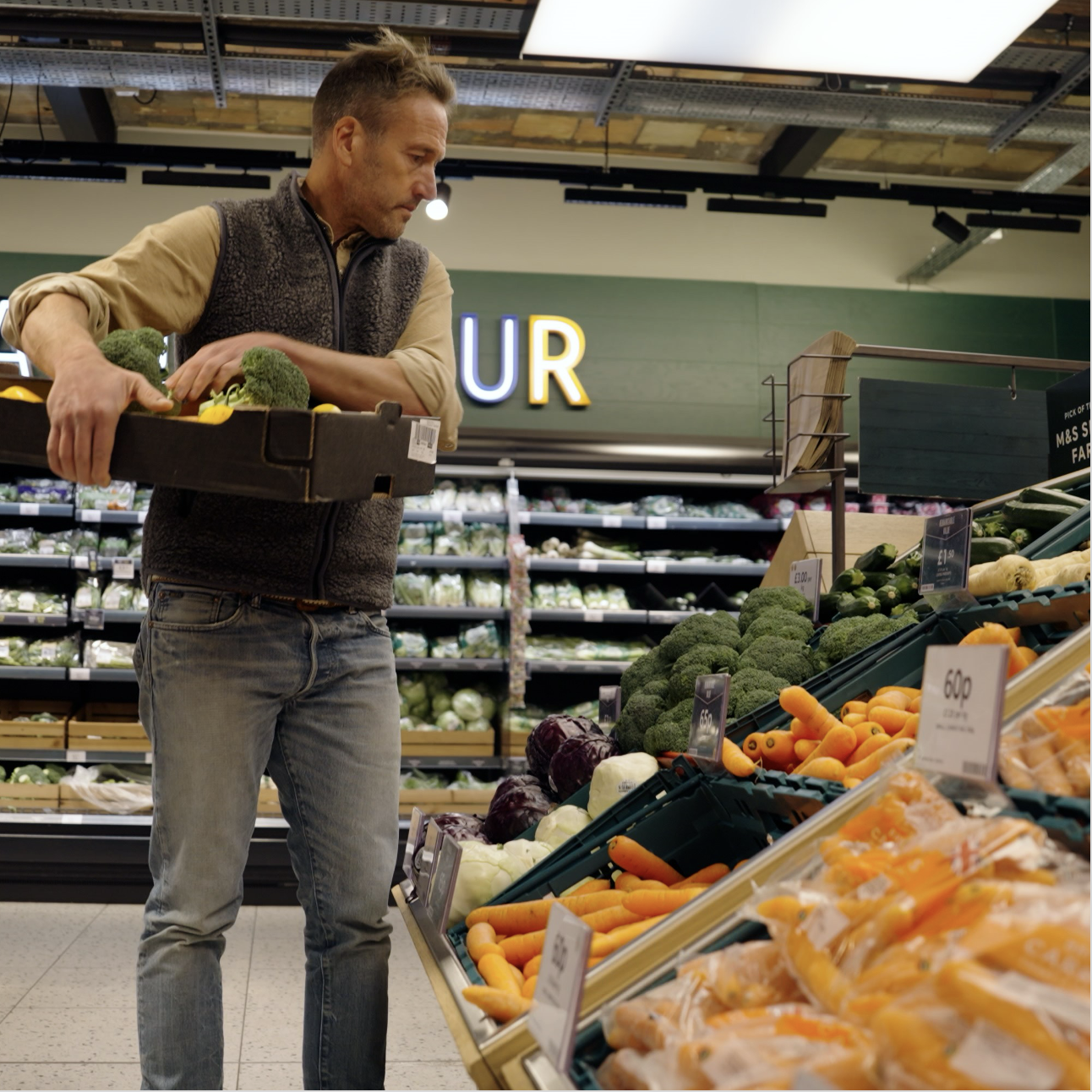 A man in the fresh produce section of a supermarket