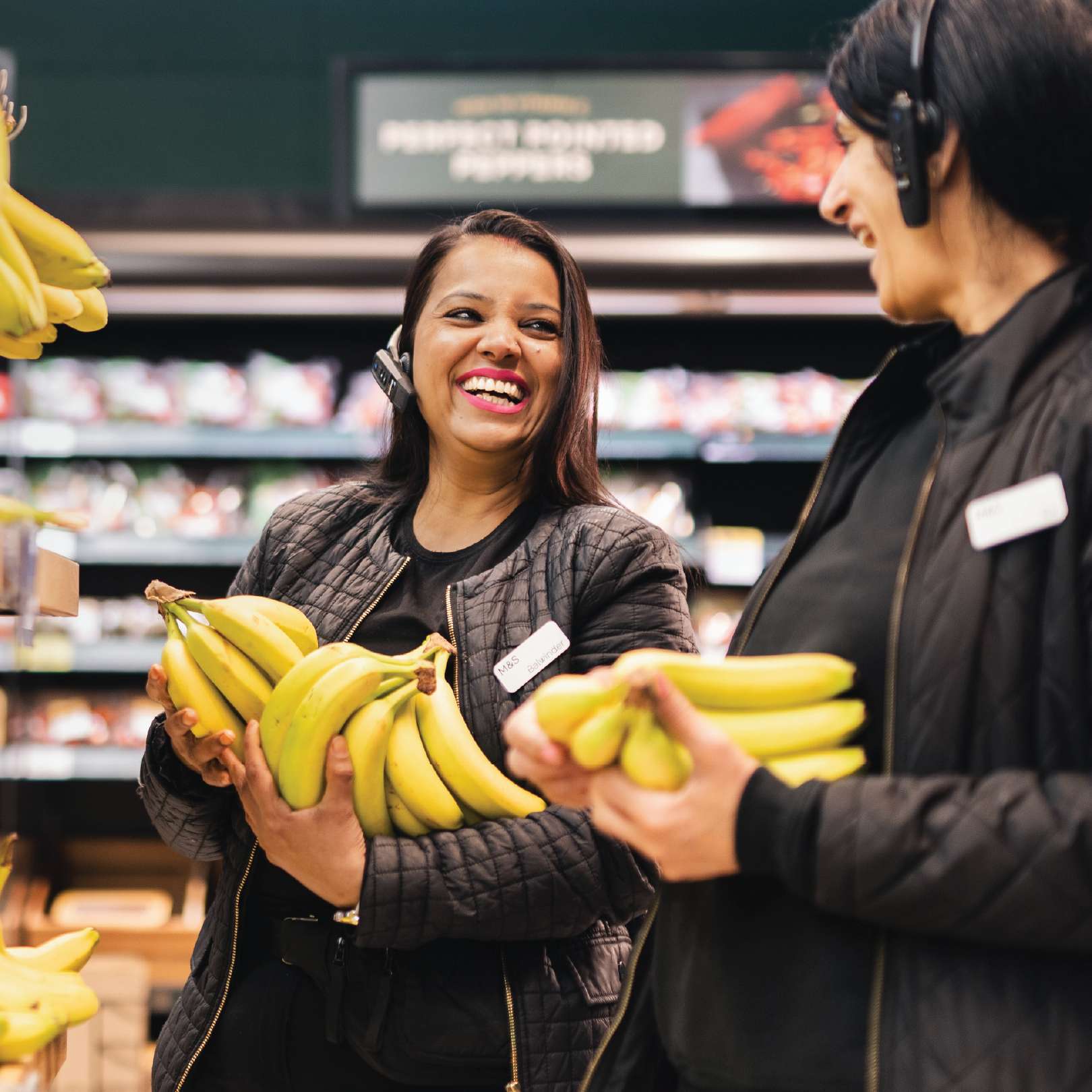 Happy M&S store colleagues smiling and holding fruit