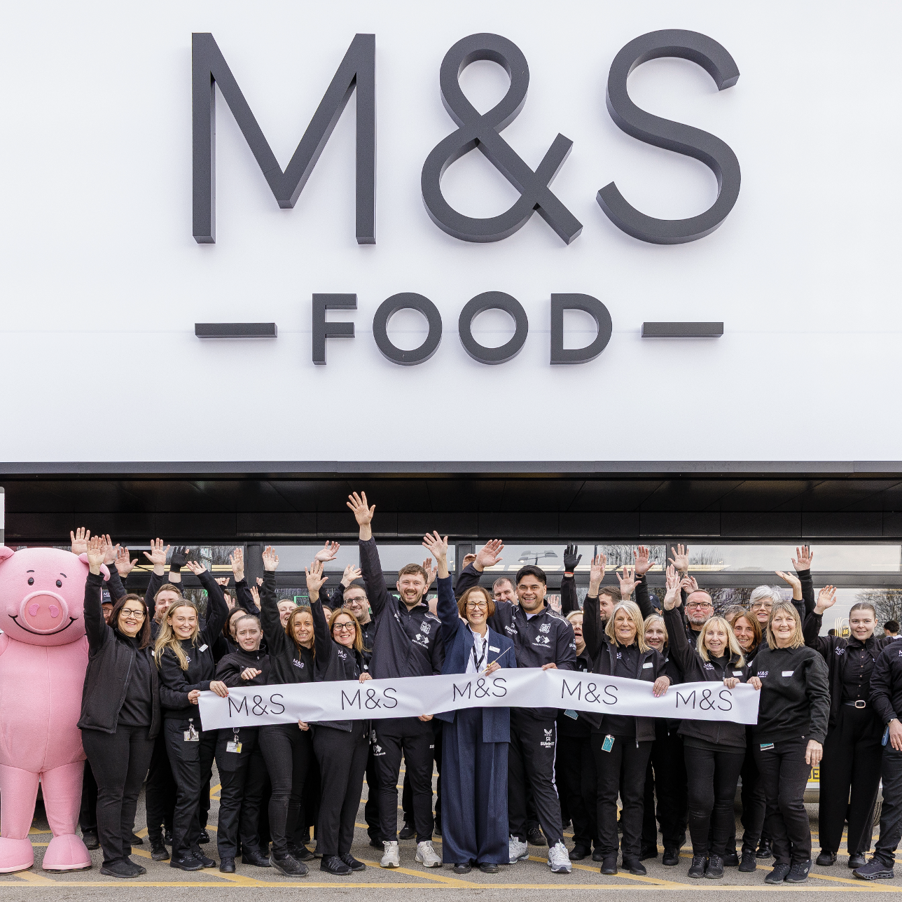 a group of people in front of an M&S Food store
