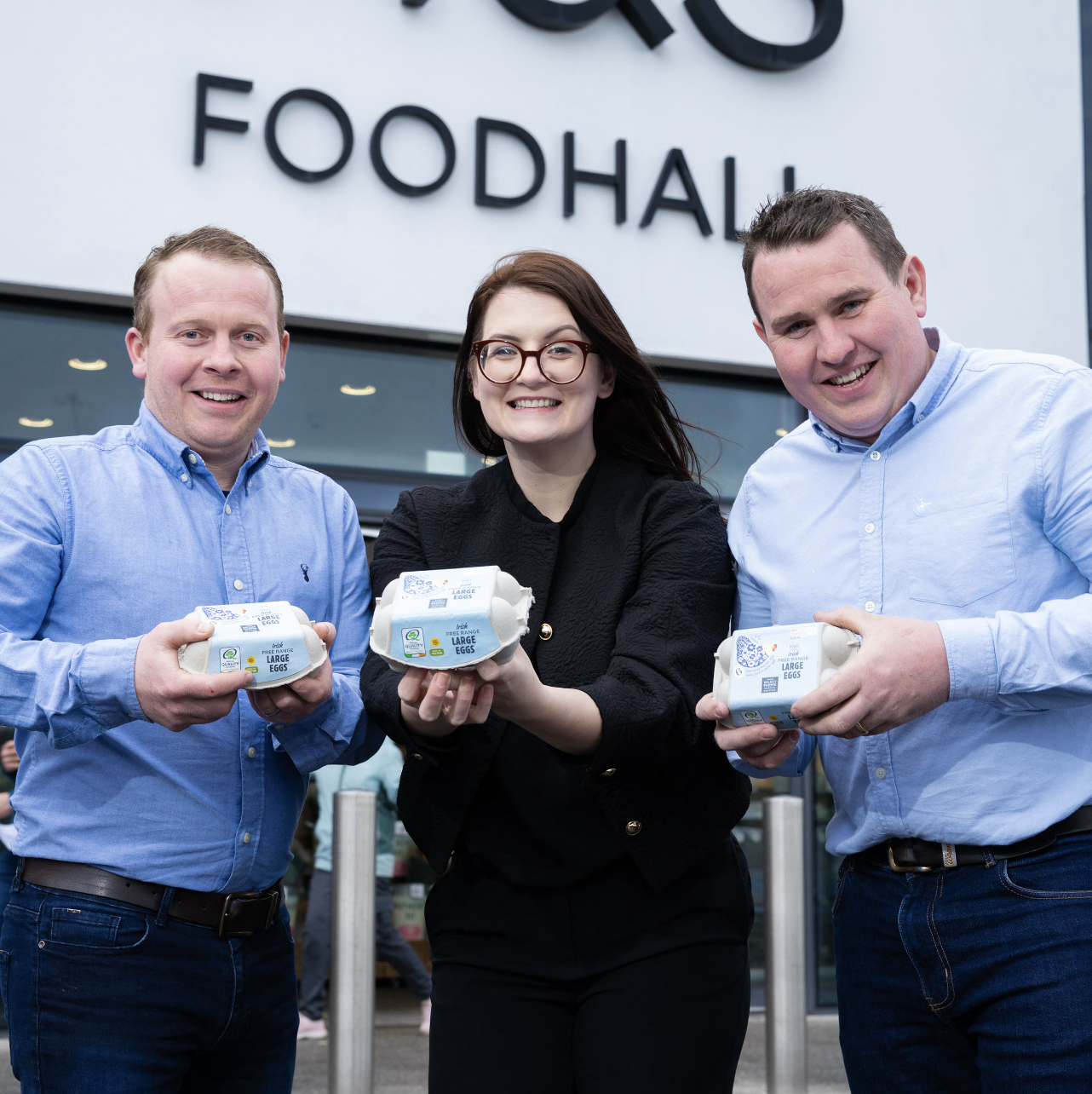 three people holding boxes of eggs