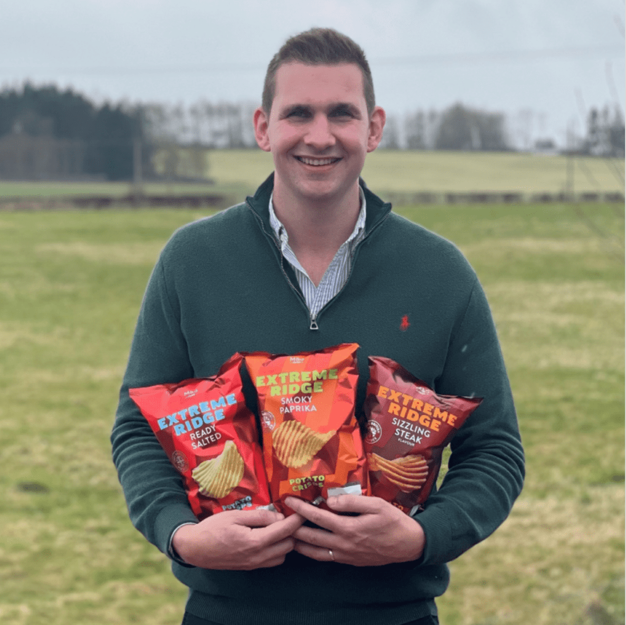 A man holding three bags of crisps 
