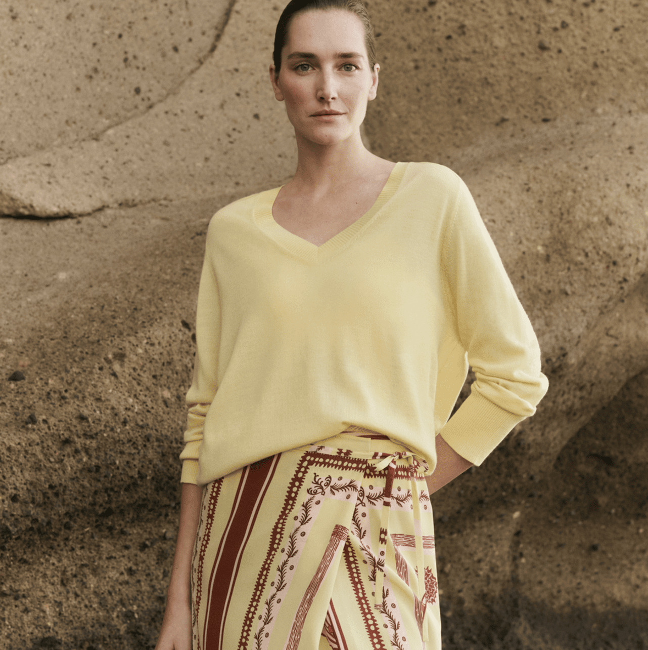 a person wearing a yellow jumper and yellow patterned skirt