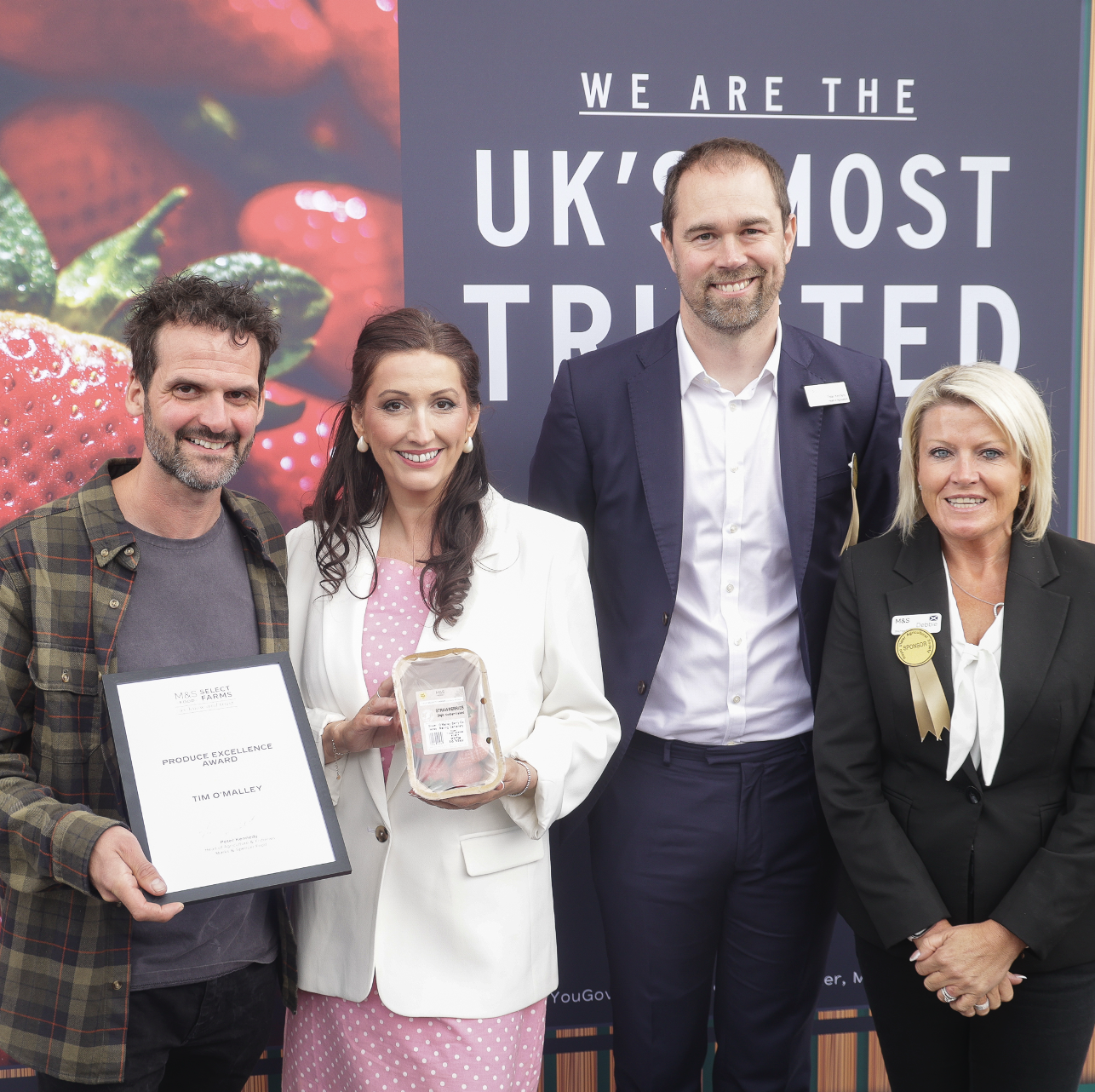 four people holding an award 