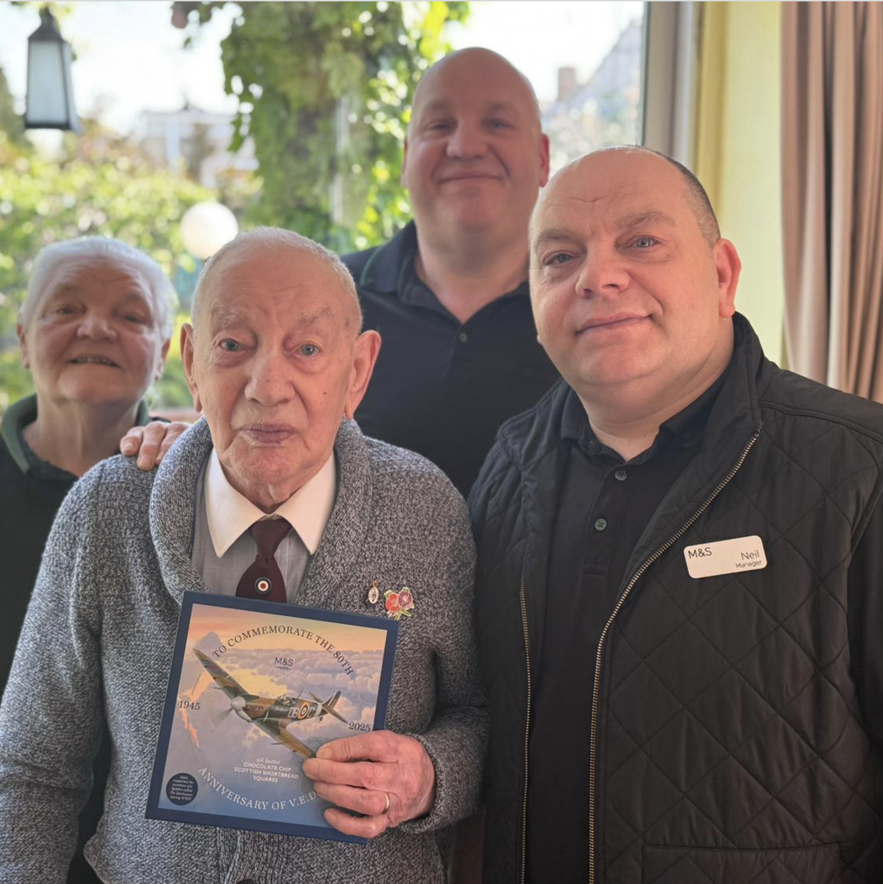 Four people standing and smiling at the camera