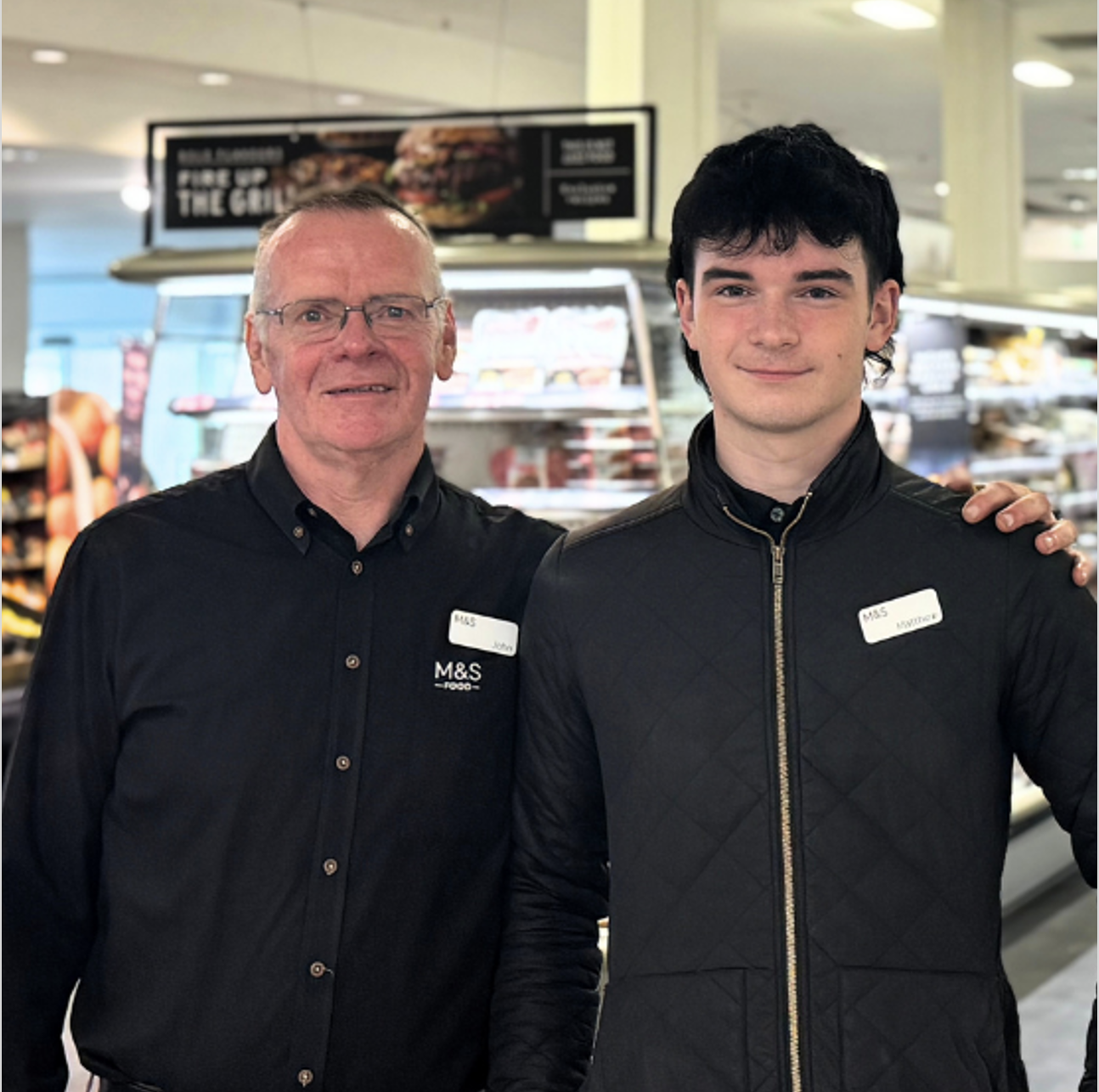 Two people in M&S uniforms smiling at the camera