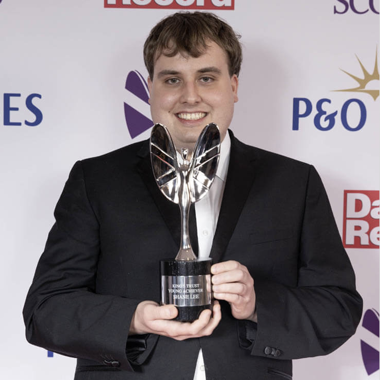 A man holding an award and smiling