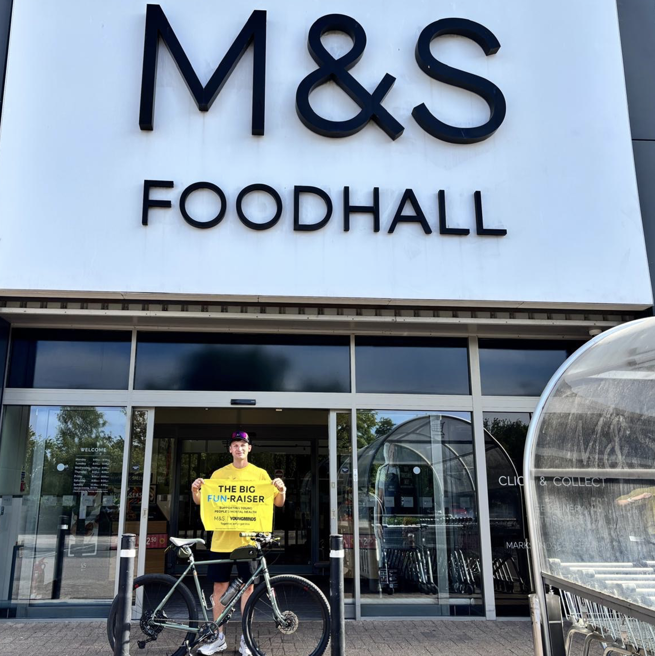 a person in front of an M&S store with a bike