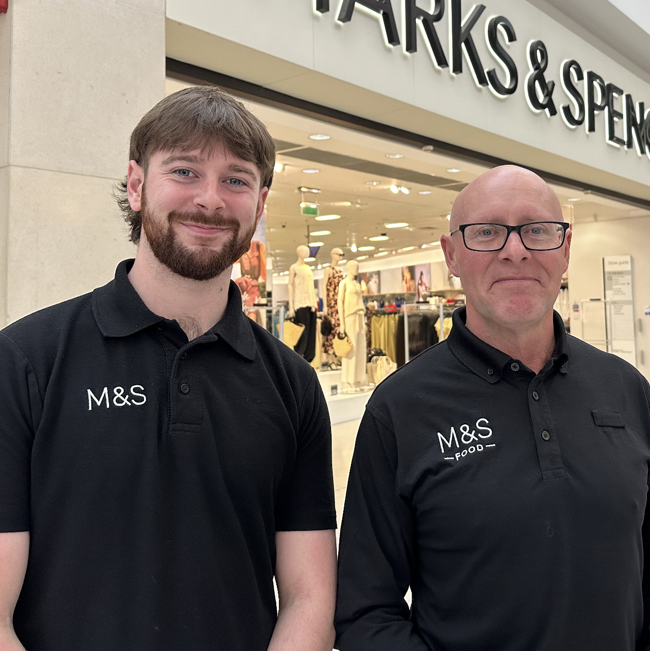 two people smiling at the camera wearing M&S uniforms 