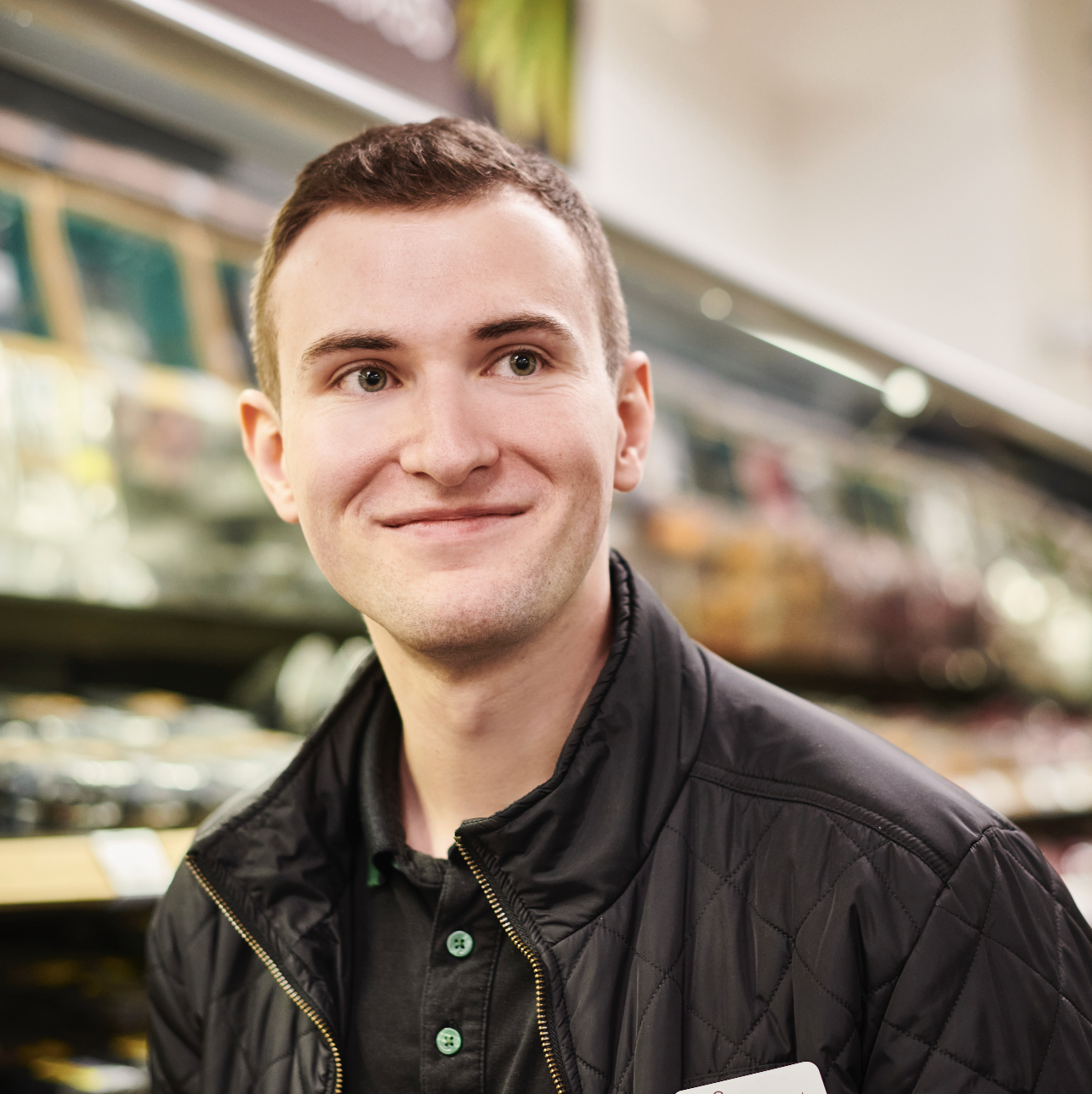 A person in a black jacket smiling at the camera