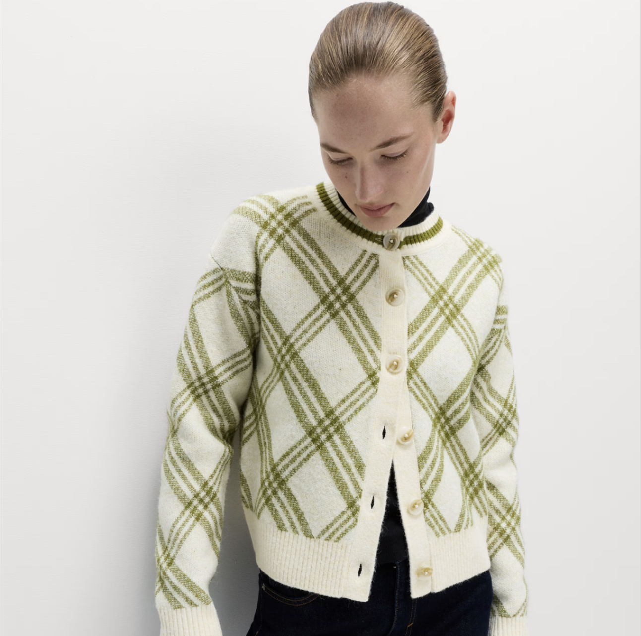 A person wearing a green and cream jumper