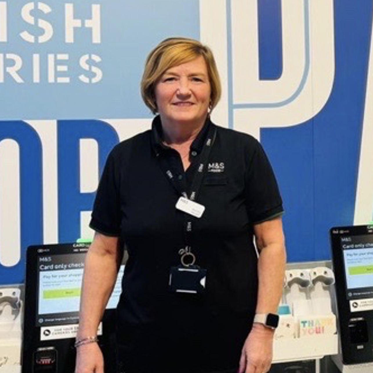 A person in an M&S uniform smiling at the camera