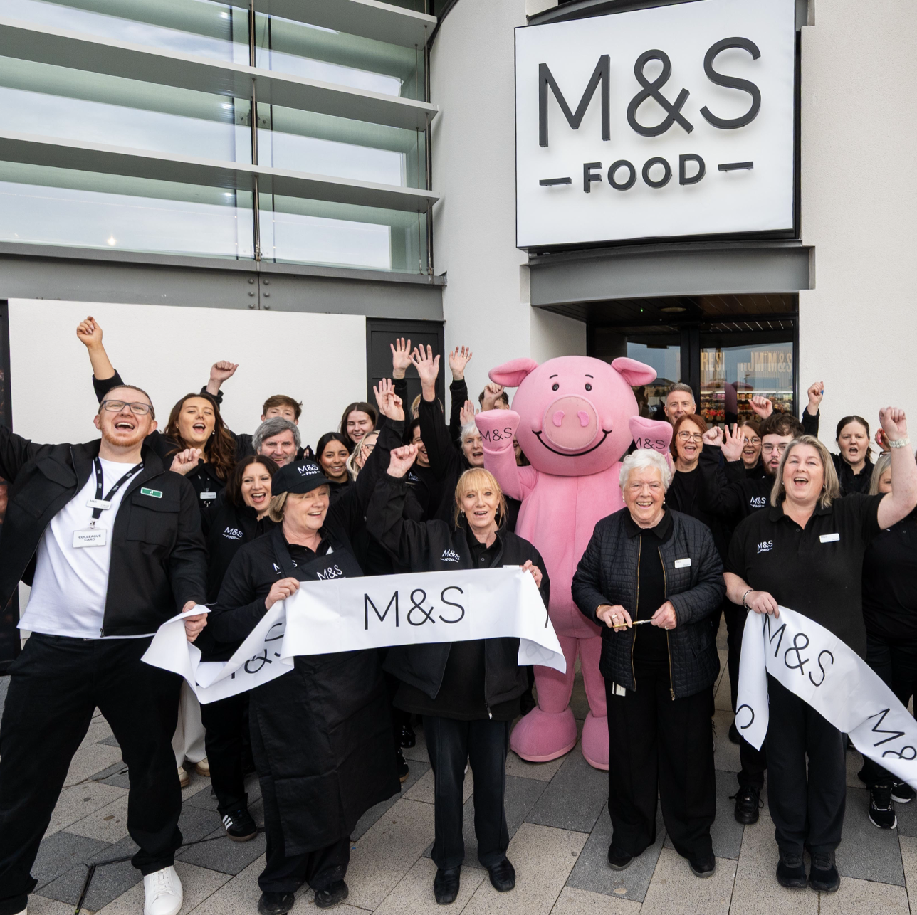 a group of people standing with a pig mascot