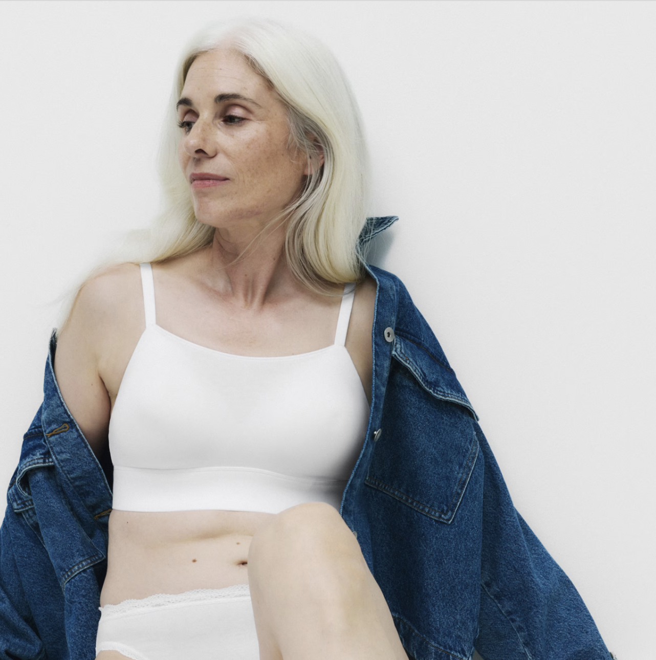 a person in a white bra with a denim jacket