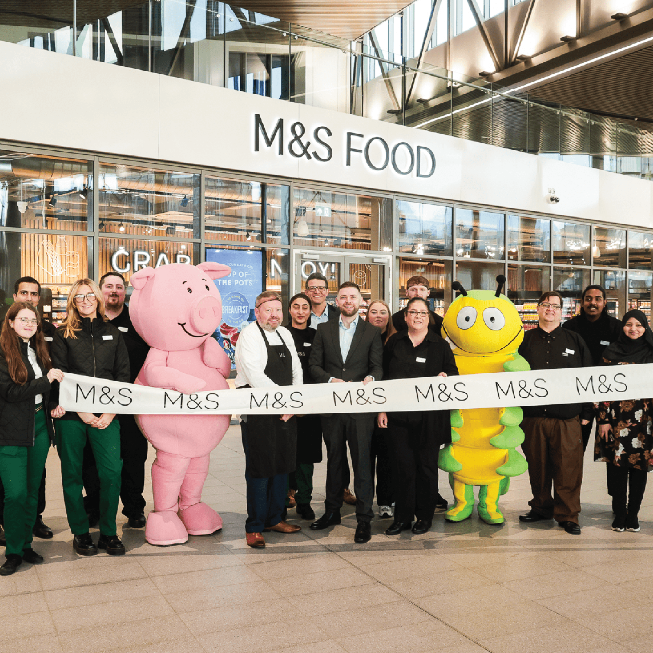 A crowd of people gathered for the opening of a new m&s store