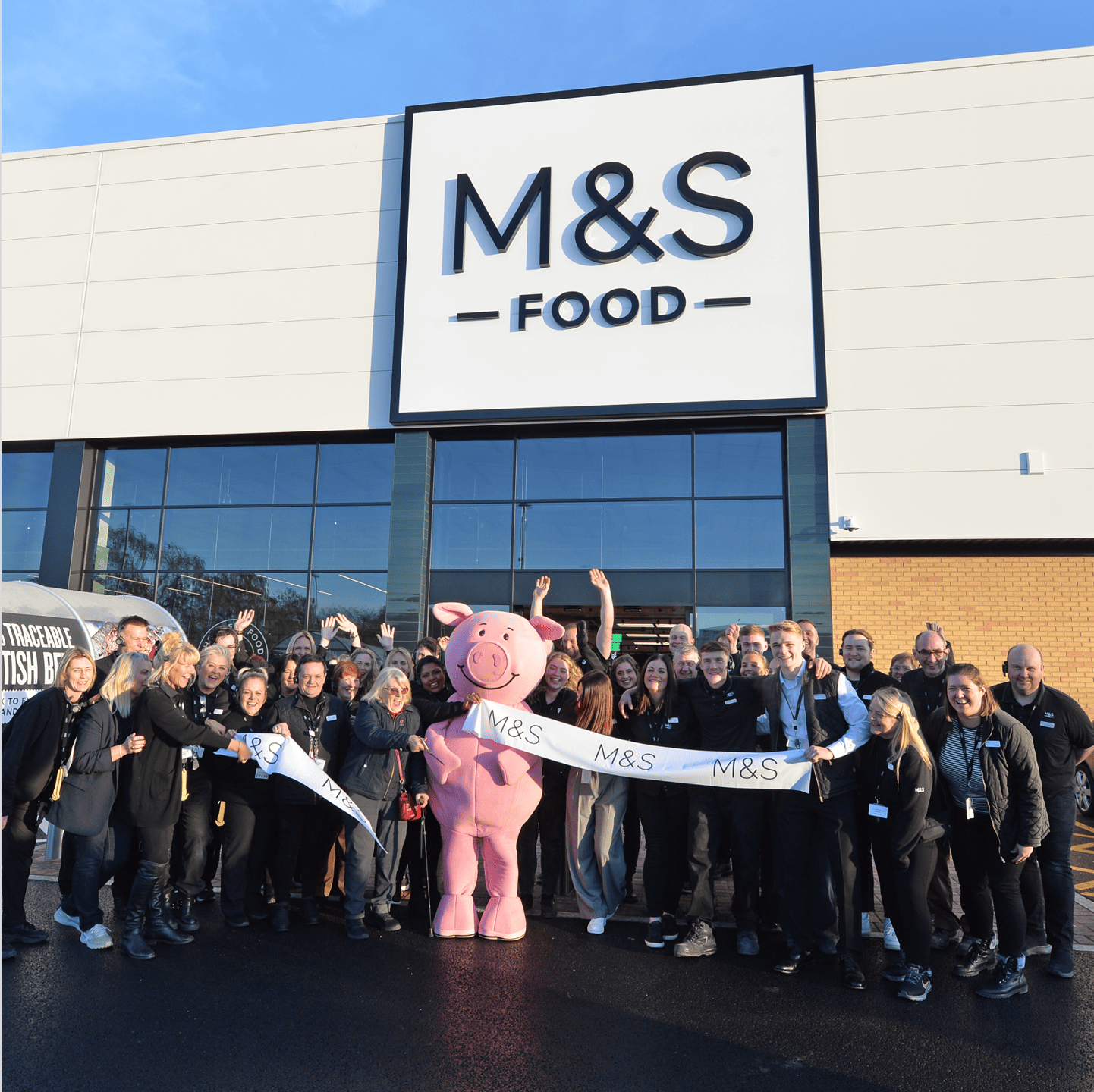 A group of people with Percy Pig for the opening of a new M&S store