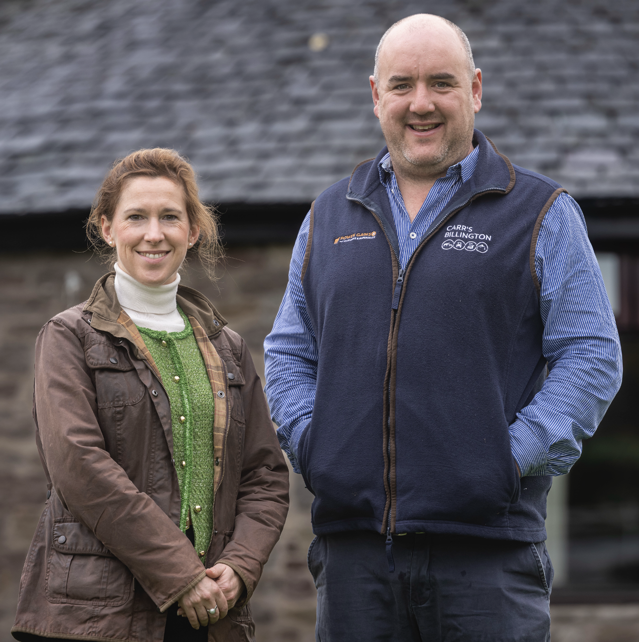 two people on a farm smiling at a camera