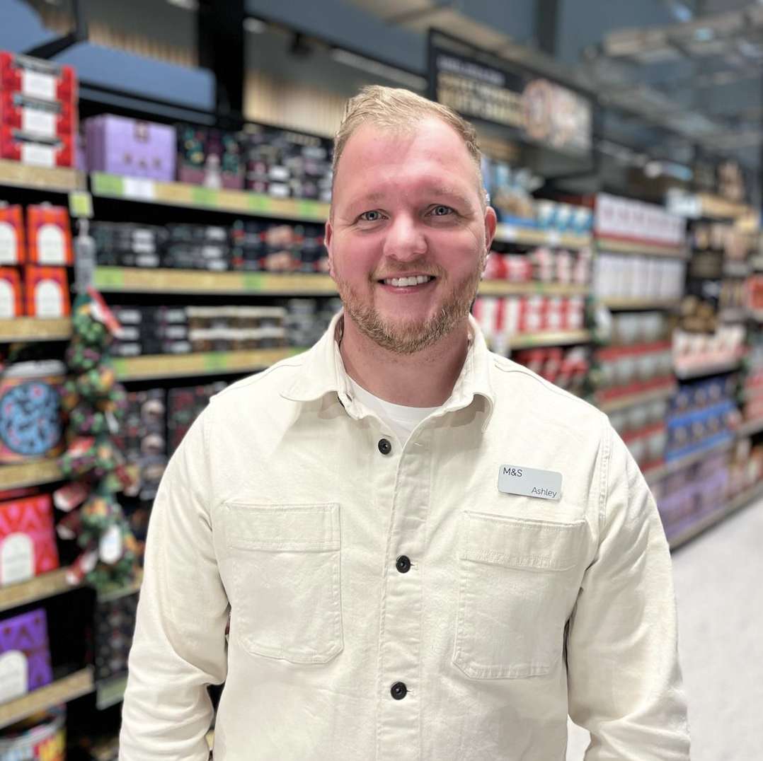 A person in a grocery store smiling at the camera