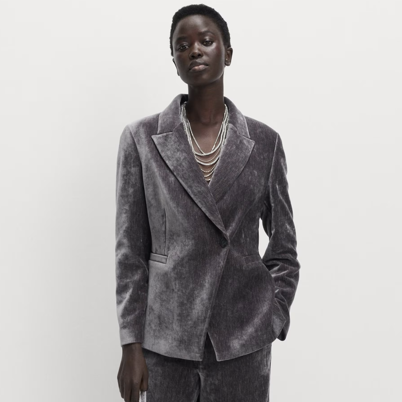 A person wearing a silver blazer