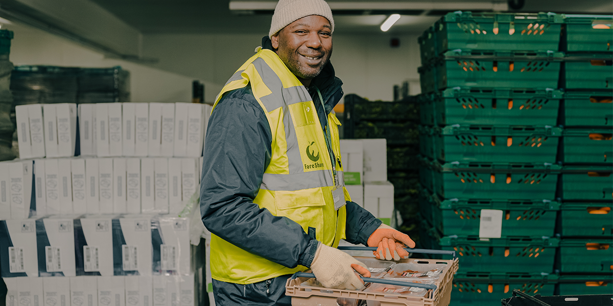 Fareshare colleague lifting crate of food