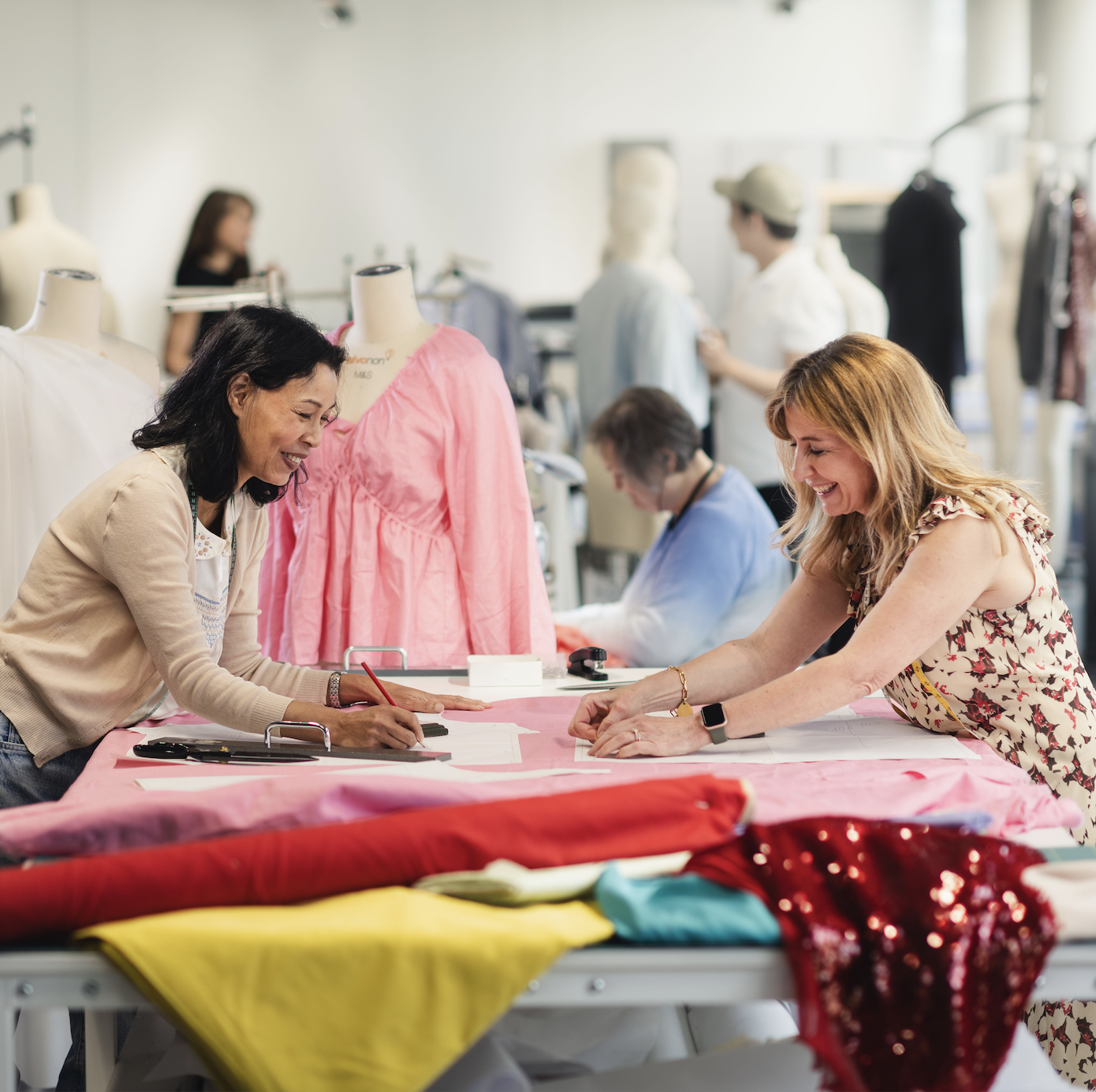 Two people working together in a clothing design room