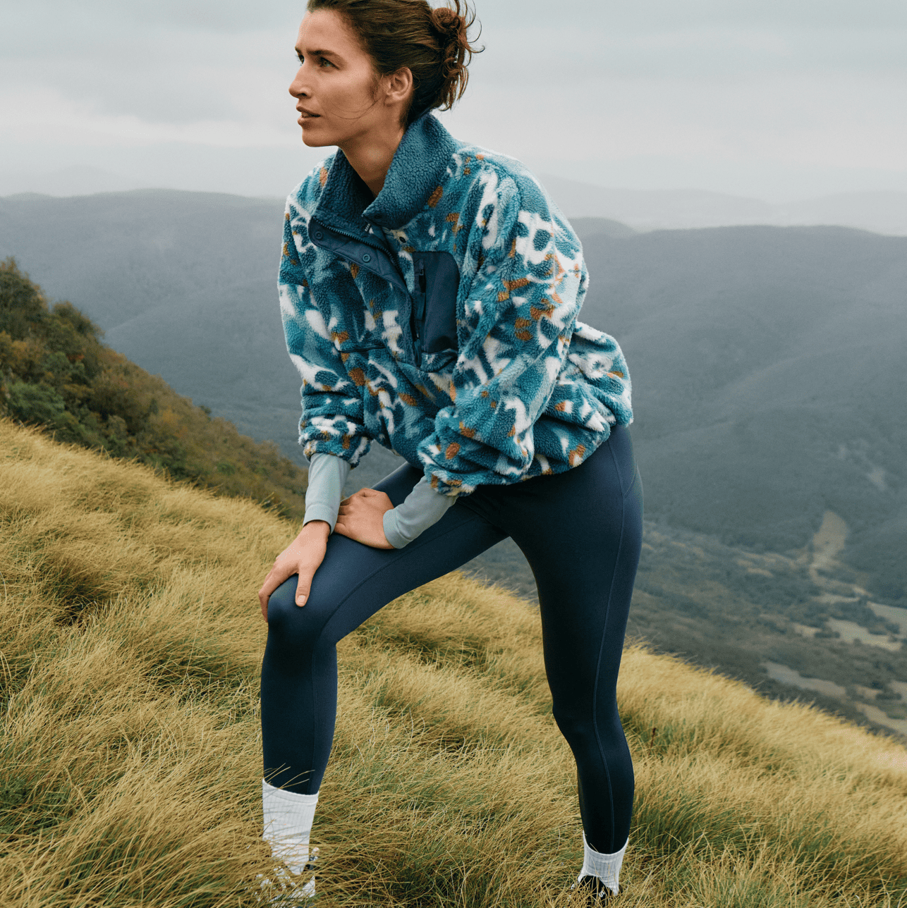 A person standing on a hill wearing sportswear
