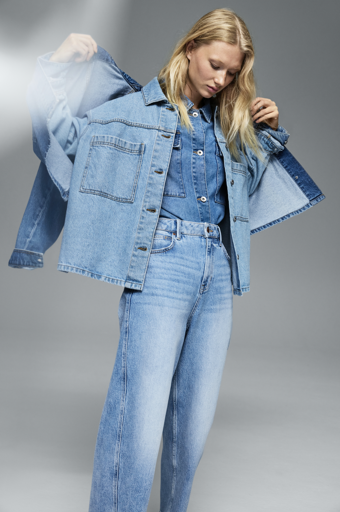 A person wearing denim jeans, a denim shirt and denim jacket