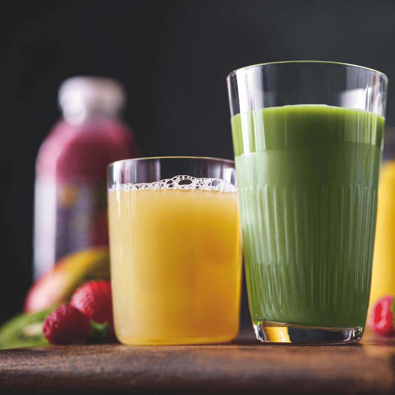 Two glasses of green and yellow juice