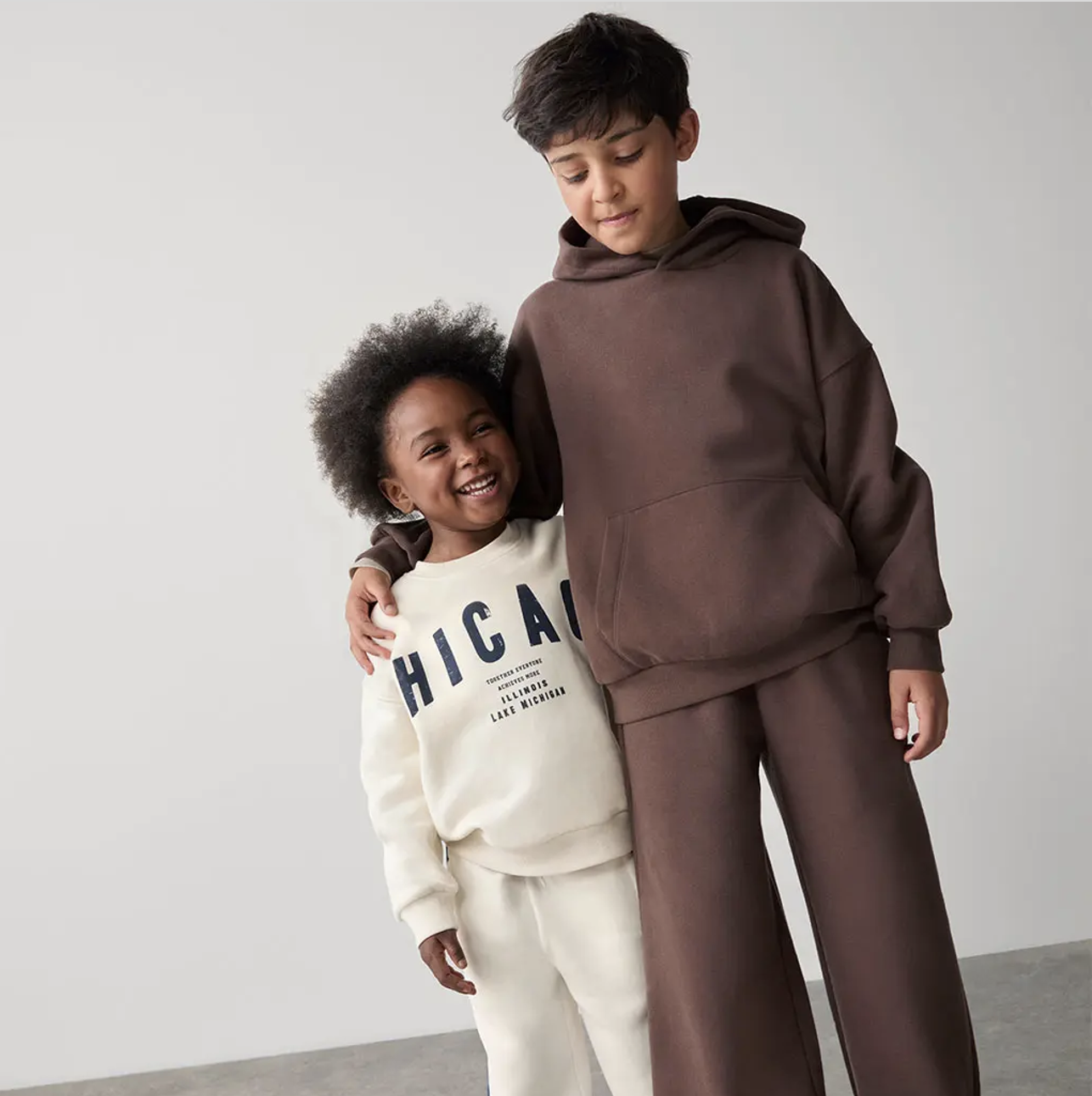 Two children, one with their arm around the other