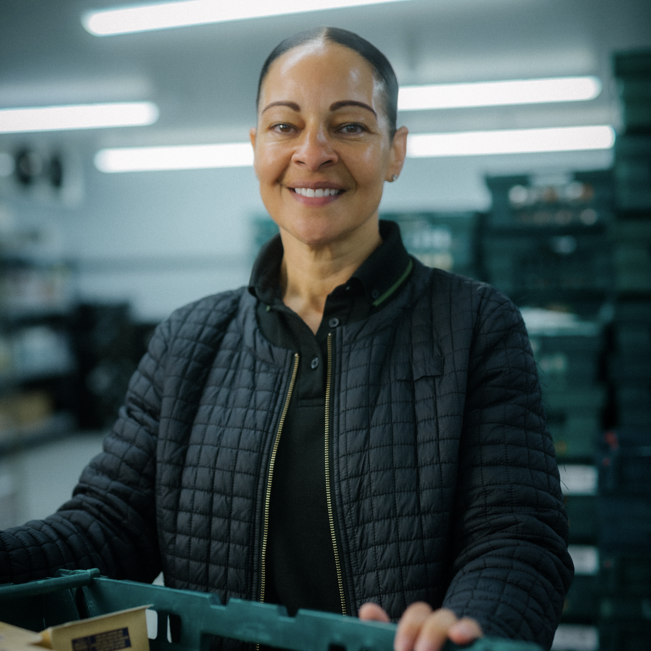 A person holding a crate and smiling