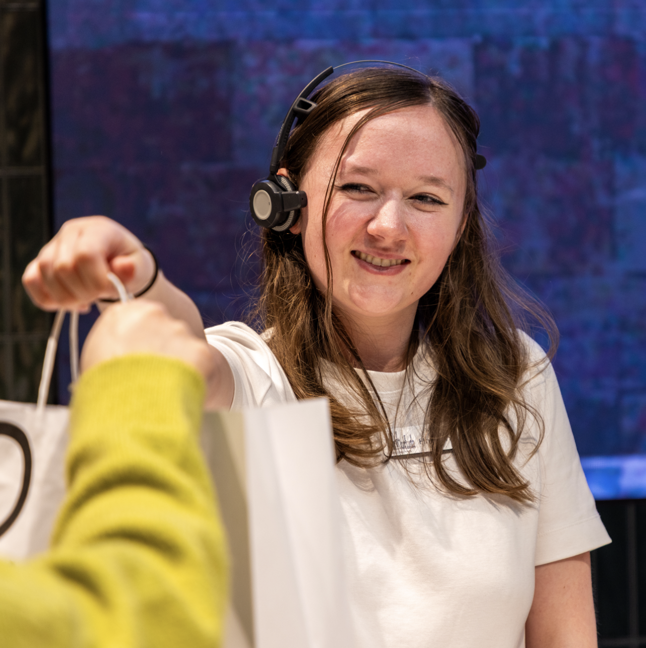 A person wearing a headset and working at a till point
