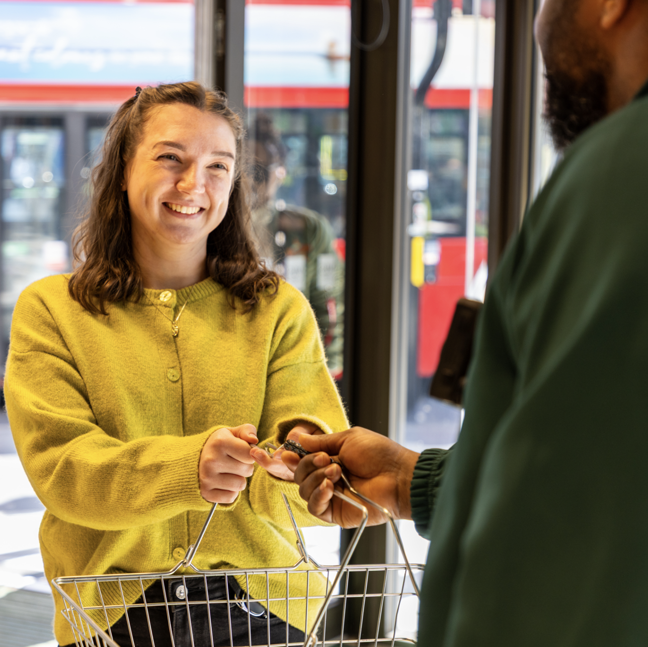 A person holding a shopping basket and smiling